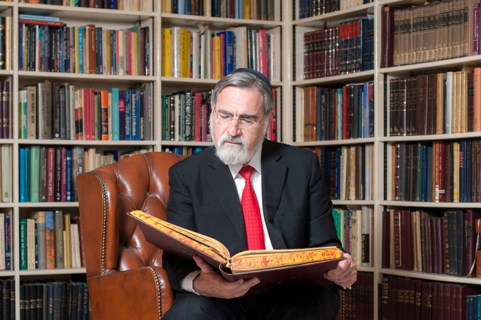 Rabbi Sacks armchair photograph study library gemara learning reading red tie