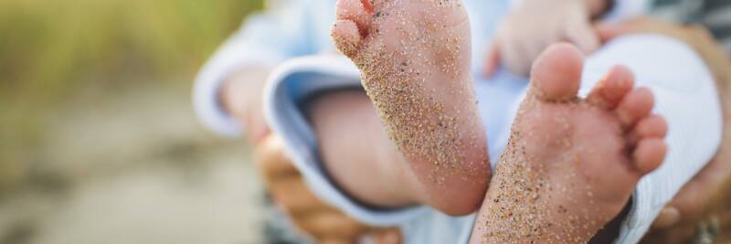 baby infant feet generations child with sand granules marks of history grains unclean dirty toes